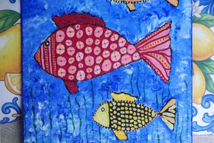 Feine Details und Texturen Sanfte Tiefe: Der strukturierte Hintergrund in verschiedenen Blautönen erinnert an sanfte Wellenbewegungen. Dezente Muster: Die Fische sind mit Mustern aus feinen Punkten, Kreisen und Linien verziert. Ausgewogene Farben: Die warmen Nuancen von Rot, Gelb und Orange harmonieren mit dem kühlen Blau des Wassers.