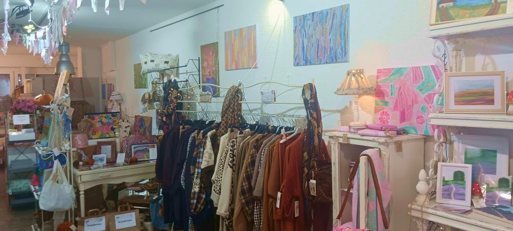 Shopbild, Bekleidung, Deko, Accessoires und Schmuck, im Hintergrund sind Bilder zu sehen